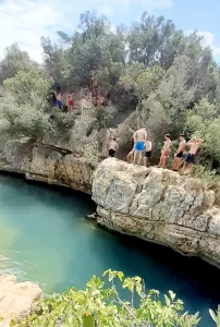 Some teenagers are cliff jumping at Fuente de Marzo